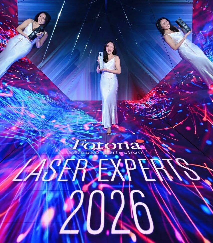 Dr. Diana holding an award trophy on stage at the Fotona Laser Experts 2026 event