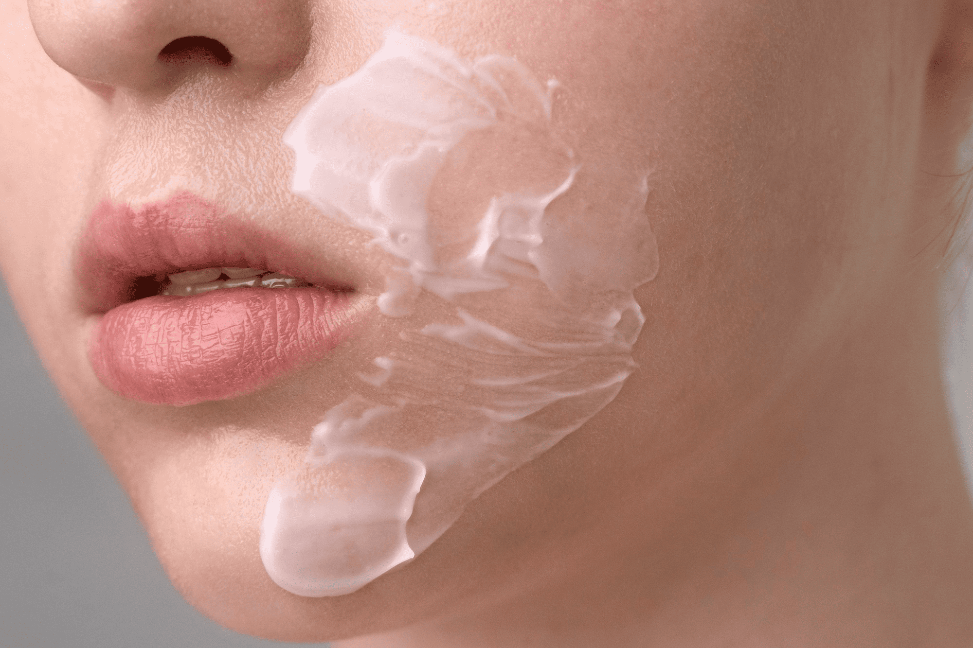 Close-up of moisturizer being applied to a woman's cheek to repair the skin barrier